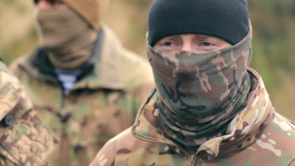 Close-up portrait of a military soldier with camouflage and balaclava on his face and black glasses. Soldier fighter hiding his face. — Stock Video