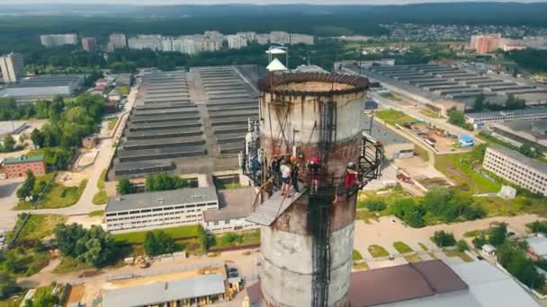 Aerial view man jumps from an extremely high height upside down. Rope jumping from the pipe of an abandoned factory. — Stock Video