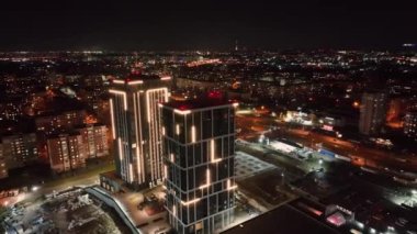 Geceleri iş merkezleri var. Gece şehri üzerinde uçmak ve aydınlatmayla aydınlatılmış yüksek katlı modern evler. İHA 'nın gece şehir manzarasının eşsiz manzarası..