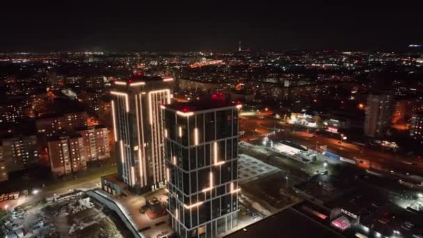 Huizen van zakelijke centra 's nachts. Vlucht over de nachtstad en hoogbouw moderne huizen verlicht door verlichting. Onovertroffen panorama van de nacht uitzicht op de stad vanaf de drone. — Stockvideo