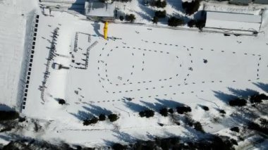 Kışın dağlarda yapılacak biatlon maratonu için büyük bir eğitim kayakçıları üssünde hava manzarası. Kayakçılar mesafeyi aşıp antrenman yapıyorlar..