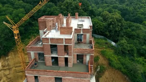 Vista aerea Costruzione di una casa di mattoni a più piani. Costruttori versare cemento all'ultimo piano. I lavoratori edili stanno costruendo una casa — Video Stock