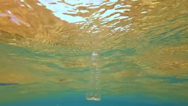 海と海のプラスチック汚染の生態系の大惨事。海面に浮かぶ小さなペットボトル. — ストック動画