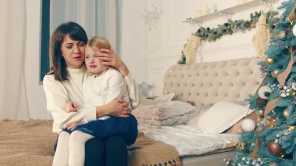 Mamma lenisce una bambina che piange la vigilia di Natale. Mamma con il suo bambino la vigilia di Natale. Piangere bambino — Video Stock