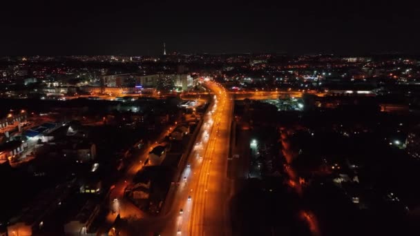 Vue aérienne Circulation nocturne sur l'autoroute reliant les grandes villes. Vue sur la ville qui brille la nuit depuis une hauteur. Vie nocturne dans la grande ville. — Video