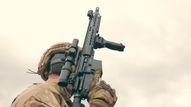 El tirador sostiene un rifle de francotirador en su mano y cubre la cara de los búhos con el rifle. — Vídeo de stock