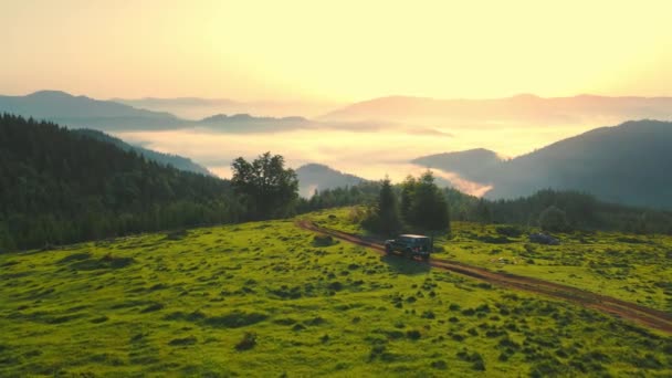 Dawn in the mountains from a birds eye view. The SUV is moving down a dirt road in the mountains. Hiking in the mountains. Sunrise in the mountains. Beautiful Ukrainian Carpathians — Stockvideo