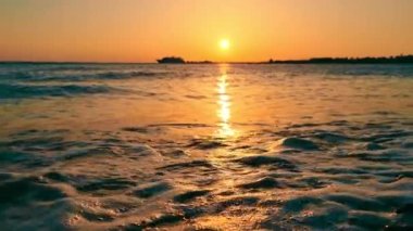 Fantastik deniz doğuşu ve dalgalar ağır çekimde. Güneş doğarken deniz manzarası. Tropikal sahilde inanılmaz bir gün doğumu. Sarı güneş denizin üzerinde.