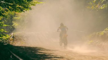 Sporcular, motosikletçiler, hızlı bir şekilde off-road pistindeki mesafeyi tarayın. Hızlı bir motosiklet yarışından sonra gelen toz ve kum..