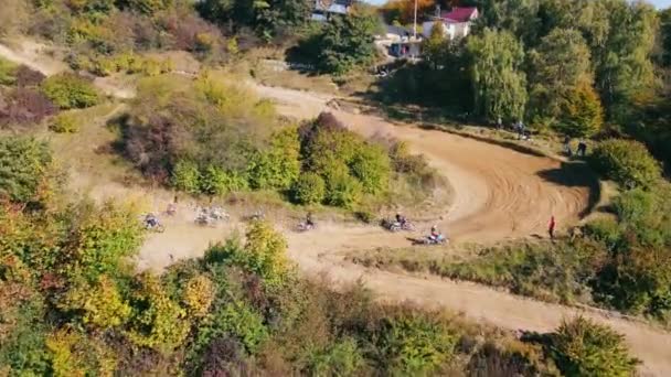 Motosikletliler bir motokros yarışı sırasında keskin bir dönüş yaparlar. Dik virajları ve sıçrama tahtaları olan off-road motokrosları. — Stok video