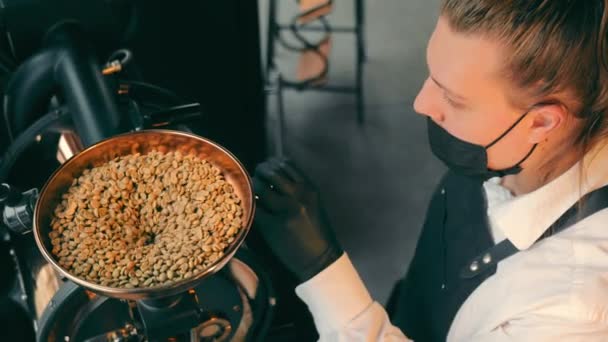 Ungeröstete rohe Kaffeebohnen werden in den automatischen Kaffeeröster geschüttet. Rohe Kaffeebohnen in den Kaffeeröster füllen. — Stockvideo