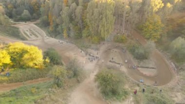 Motosikletliler bir motokros yarışı sırasında keskin bir dönüş yaparlar. Dik virajları ve sıçrama tahtaları olan off-road motokrosları.