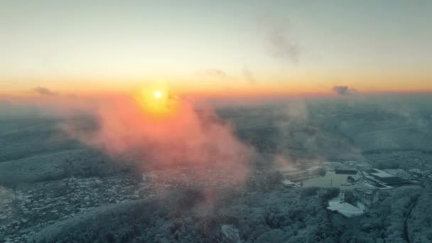 Όμορφο ηλιοβασίλεμα από εναέρια θέα πάνω από χιονισμένη πόλη το χειμώνα. Βραδινές ακτίνες του ήλιου και χρωματιστά σύννεφα και ακτίνες του ήλιου. Απίστευτη φύση και τοπίο — Αρχείο Βίντεο