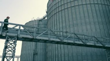 tarım çiftçisi tahıl, soya fasulyesi ve buğday depolama tanklarını kontrol ediyor.