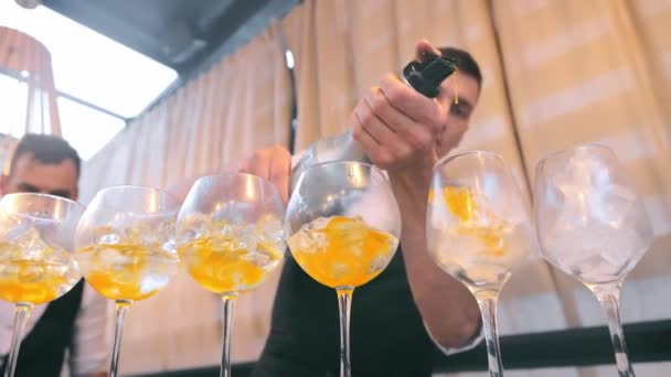 Ukraine Lviv 10.02.2022 Preparation of cocktails.酒保立刻准备了一小滴鸡尾酒.酒保把酒精倒入装有冰块的杯子里. — 图库视频影像