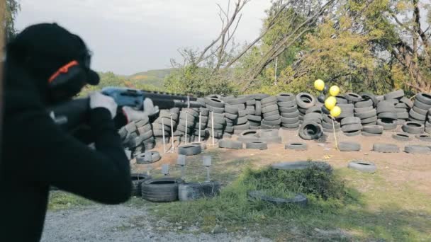 Uma mulher dispara com uma arma de caça de furo de sabão em bolas amarelas. Presente de aniversário para uma mulher na gama de tiro. — Vídeo de Stock