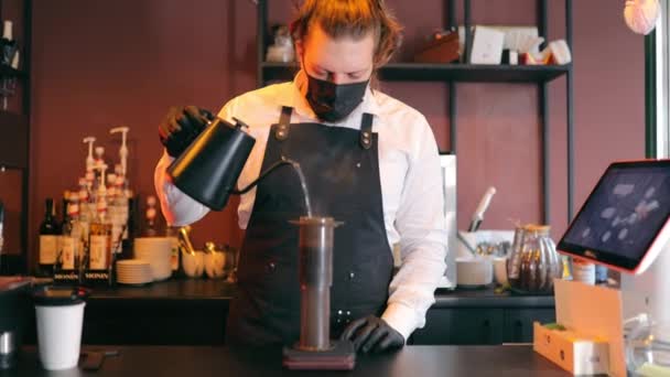 El marido de los baristas está observando atentamente mientras se vierte agua caliente en el filtro de café. Camareros ver en la fabricación de café alternativo. Café al vapor en el bar. — Vídeos de Stock