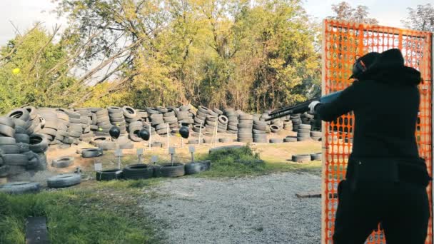 Une femme tire à partir d'une arme lisse de chasse aux boules jaunes avec l'inscription joyeux anniversaire. Cadeau d'anniversaire à une femme au stand de tir. — Video