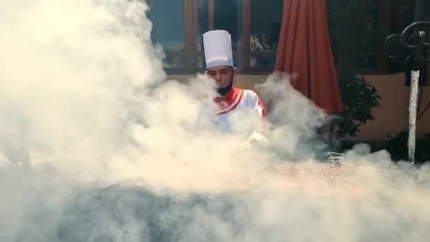 Egipto, Hurghada - 18 de febrero de 2022. Comida callejera. El chef prepara carne en la calle. Hay mucho humo cocinando. El chef tuesta carne de pollo en la parrilla. — Vídeo de stock