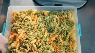 Teslimat için plastik bir kapta makarna. Karıştırma ve paketleme sıcak makarna daha fazla teslimat için.