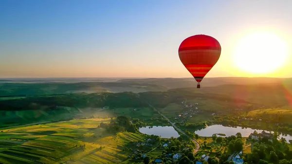 Ein Ballon fliegt bei Sonnenuntergang in der Mitte des Horizonts. Bilder — Stockfoto