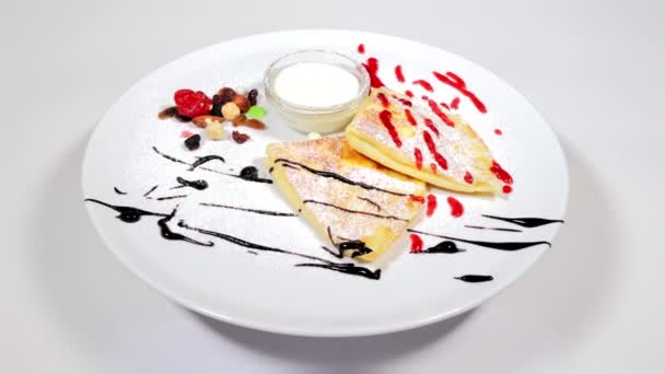 건강 한 식사. 아침 식사 로 팬케이크 팬 에 신 크 리임 잼 과 견과류를 넣어 흰 접시에 얹는다. 아침으로 집에서 요리 한 식품 팬케이크. — 비디오