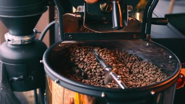 Side view of coffee beans cooling in cooling tray after being roasted. Close up view of coffee roasting machine mixing beans of coffee, rotating in copper tray. Concept of coffee production — Stock Video