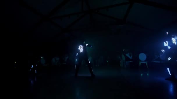 Светодиодное шоу в ночном клубе. Впечатляющие танцы молодых людей, светящихся в темноте с освещением Led. Лазерное шоу. — стоковое видео