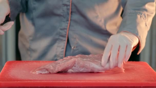 ナイフで生肉を切って閉じる。シェフは豚肉を遠隔調理用に切り分けています. — ストック動画