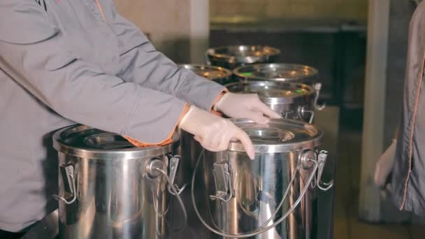 Woman closes a container for transporting hot food. Remote kitchen and cooking for further transportation. The cook closes the airtight container with cooked food — Stock Video