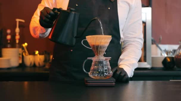 Przygotowanie kawy. Barista wylewa wrzącą wodę na kawę i filtruje ją. — Wideo stockowe