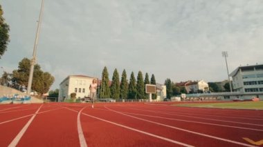 Sporu bitirip bitiş çizgisine koşan bir sporcu. Koşucuyu durdur ve derin nefes al ve eşit nefes al. Stadyumda sırt çantasında koşuyor..