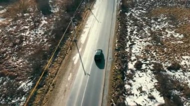 Kışın kırsal bölgede kar yağarken araba sürüyor. Güneşli bir sabahta, yol ayrımıyla birlikte otomobilin yukarıdan görünüşü güneşli yolda ilerliyor. Seyahat kavramı