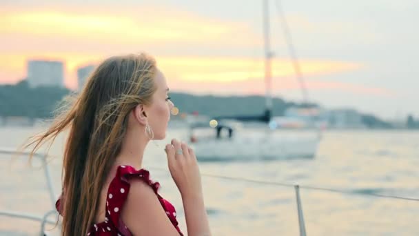 Un viaje en yate. Relájate al atardecer. Chica joven y bonita descansando en un yate y relajante. — Vídeos de Stock