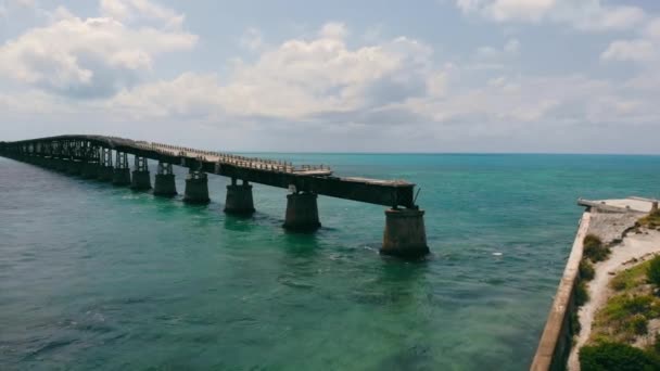 Puente roto que corre sobre la superficie del océano en Florida Keys, EE.UU. Vista aérea desde el dron del viejo puente de Bahía a lo largo del océano con paisaje oceánico horizontal, con espacio para copias. Concepto de arquitectura — Vídeos de Stock