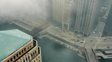 Chicago şehir merkezindeki hava manzarası, araba trafiği ve kuş bakışı şehir hayatı. Banliyö metro trenlerinin ve insanların yoğun saatlerde yaptıkları hareketler. Chicago Illinois ABD 'de bulutlu bir gün ve sis.