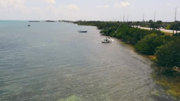 Yates inundados cerca de la orilla. Los efectos de la tormenta. Dos yates están inclinados hacia un lado en un banco cerca de la orilla que se hundió después de una tormenta o tifón frente a la costa de Florida en los Estados Unidos. — Vídeo de stock