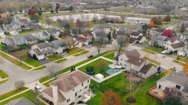 Lakóházak a külvárosi kerületben a város, a tó a háttérben. Légi felvétel a külváros drónjáról, kis hangulatos házakkal ősszel, Chicago külvárosában, Illinois államban, USA-ban. A külvárosi élet fogalma — Stock videók