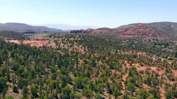 Landscape and nature of Arizona in the United States. National Natural Park with mountainous terrain. A small settlement at the foot of the mountain and the valley is covered with green trees. — Vídeo de stock