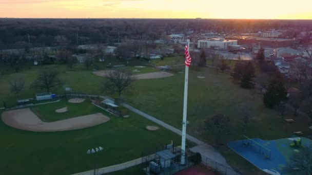 Αεροφωτογραφία Αμερικάνικη σημαία στο ηλιοβασίλεμα. Της σημαίας των ΗΠΑ κυμαίνεται από τον άνεμο. — Αρχείο Βίντεο