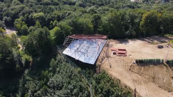 Utsikt ovanifrån över byggandet av en liten restaurang eller hus i skogen och naturen. Hantverkare bygga ramen för ett hus i skogen på berget — Stockvideo