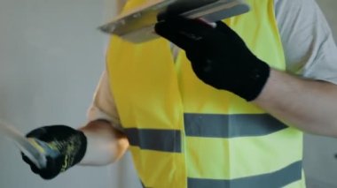 Daire yenileme konsepti. Spatüllere macun karıştıran boyacı.