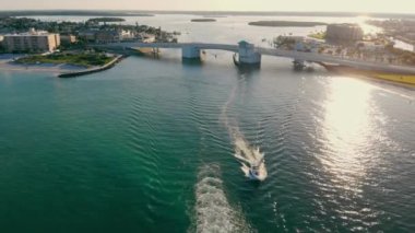 Hava görüntüsü. Gün batımında hız kazanan bir sürat teknesi. Güney Florida 'da körfez. Teknesi olan güzel bir körfezin güzel manzarası. Denizde parlayan güneş ışınları.