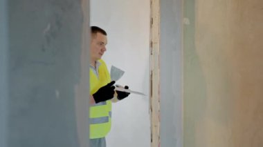 Dairelerin tamiri ustası duvarları alçıyla hizalar. İnşaat alanlarında boyama ve alçılama çalışmaları