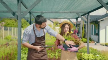 Çiçekçiler ve bahçıvanlar çiçeklerle ve bitkilerle ilgilenirler. Bahçıvan saksıları inceler ve tabletteki bilgiyi tarif eder. Elinde çiçeklerle saksıları tutan kız yardımcı..