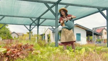 Bitki bakımı. Çiçekleri sulama kabıyla sulamak. Kadınlar çeşitli bitki ve çiçekleri sularlar. Bahçıvan bitkileri suyla sular.