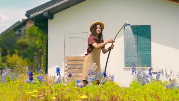 Femme Heureuse Arrosant Des Fleurs Près Maison Par Une Journée — Video