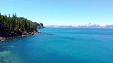 The amazing beauty of a high mountain lake in California. The nature and landscape of rocky mountains covered with snow and a crystal clear lake.