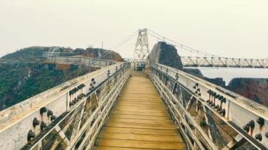 Pedestrian suspension bridge between rocks. Viewpoint for tourists. A tourists view of a walk on the bridge