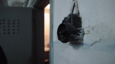 Old light switch. A mans hand in a dark room turns the light on and off with an antique switch